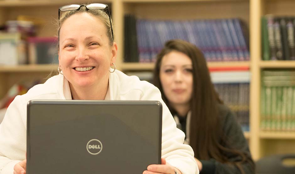 Student sitting at a laptop in the classroom