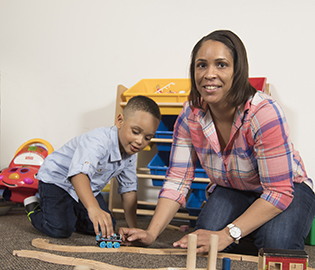 Student Smiling and playing with a child