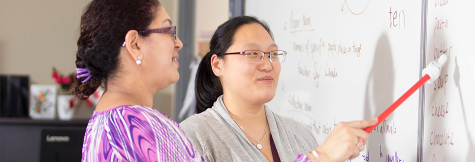 A student and teacher at the whiteboard