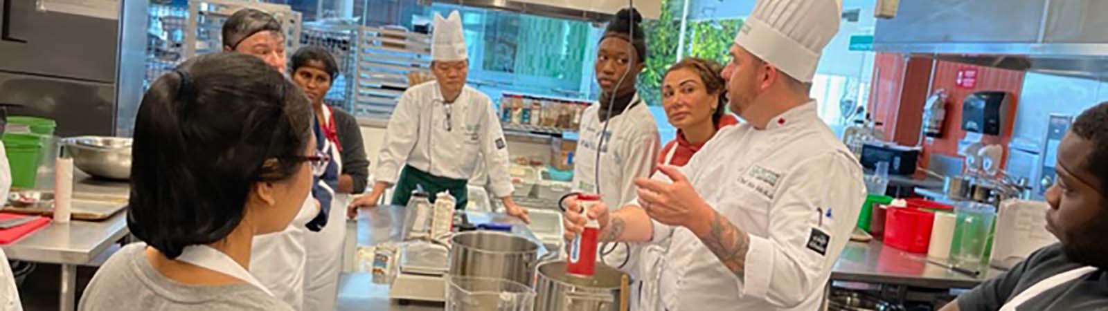 Students learning from a chef in a food lab for Adult Dual Credit