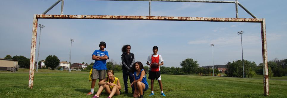 Male and female student standing under the football posts outside